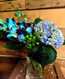 Exotic blue dendrobium orchids are paired perfectly with blue hydrangea that has a hint of green shimmer, a little lime green hypericum adds a pop to the blue.
