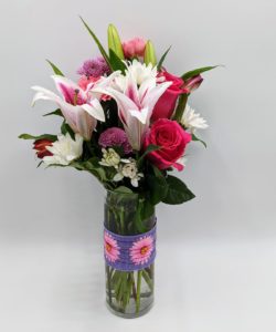 Perfectly pink stargazer lily, daisies and button mums, pink carnations and alstroemeria are in this playful bouquet! In a modern cylinder vase with a fun ribbon wrap, it's a joyful gift for any occasion.