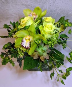 A celebration of Spring in an elegant style. Green hydrangea, button mums, roses, succulents and cymbidium orchid blooms. 