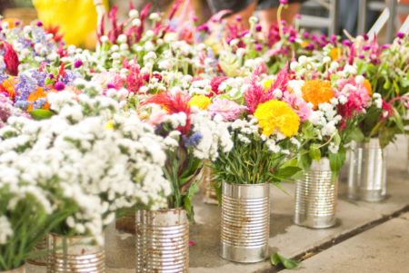Colorful flowers in tin cans