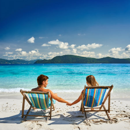 Couple in loungers on a tropical beach